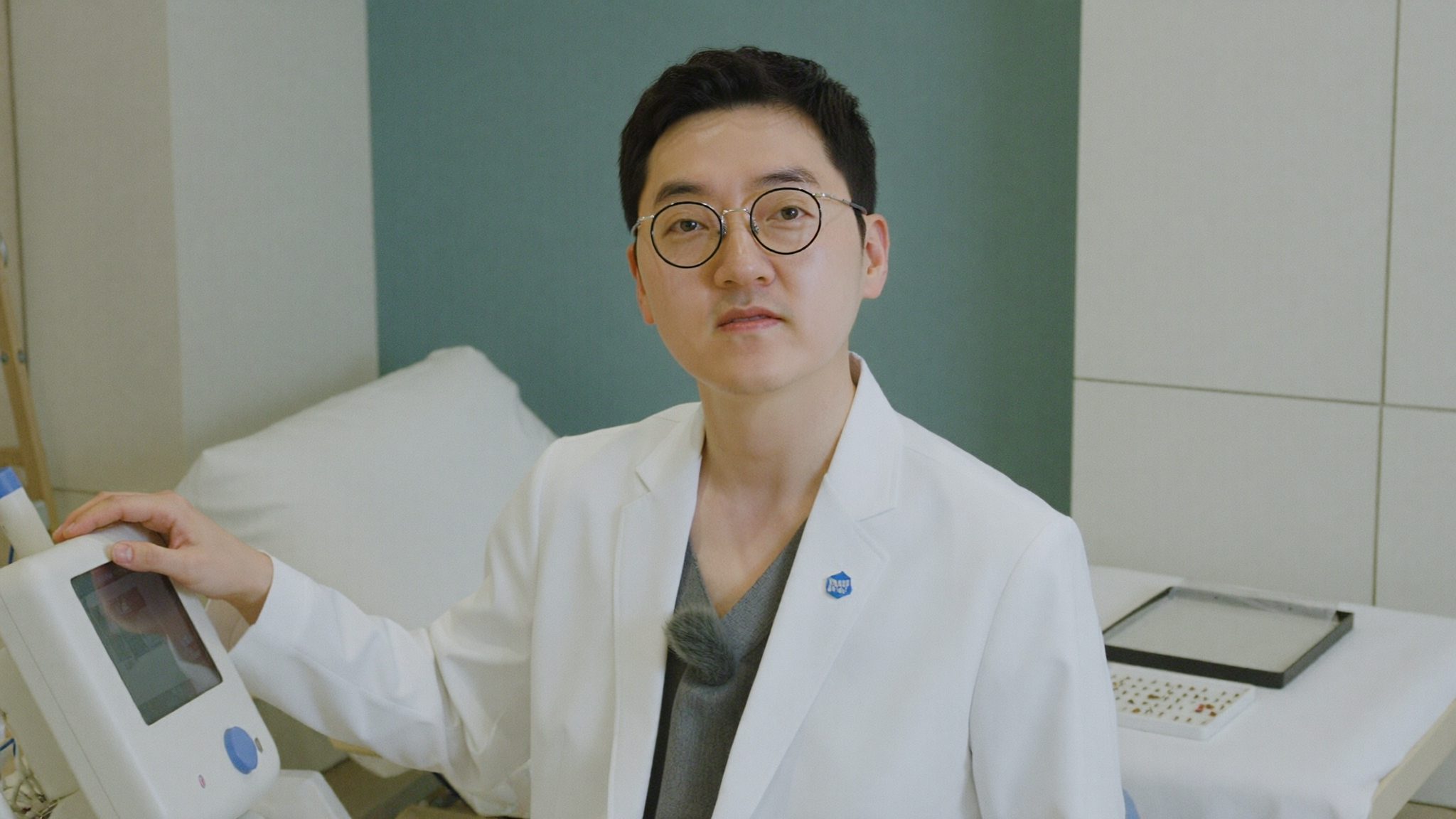 Dr. Jung Min Su, co-director at Link Plastic Surgery, checking laser settings in the treatment room.
